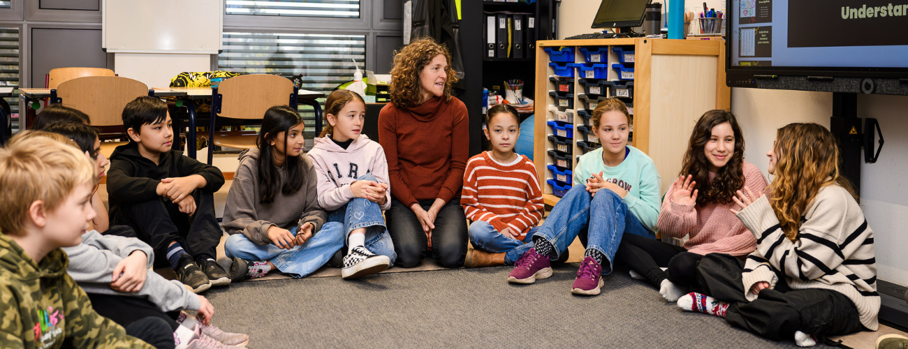 Teacher with students sitting in circle