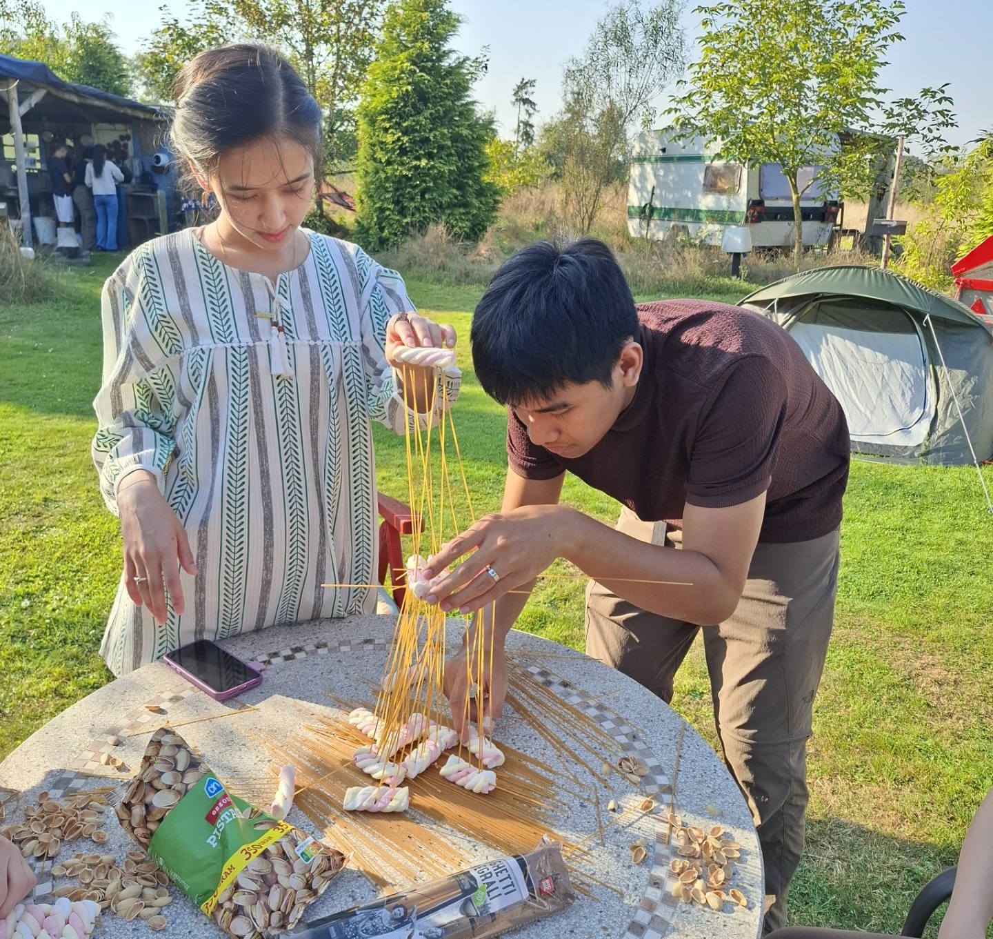 Louis in camp, building a tower with marshmallows and spaghetti